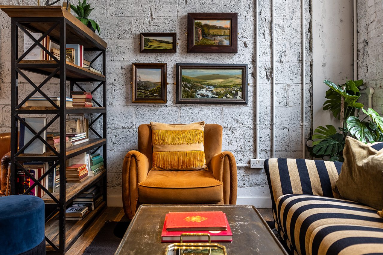 Coworking lounge with sofas and lamps at Kindred Hammersmith